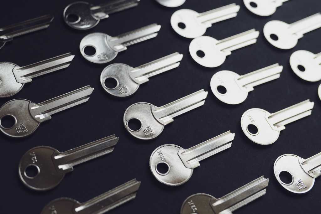 A spread of silver metal keys on a black background
