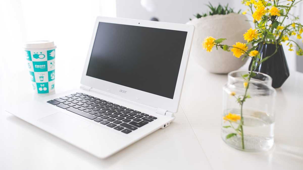 Acer Chromebook sur bureau blanc avec une fleur en vase à côté