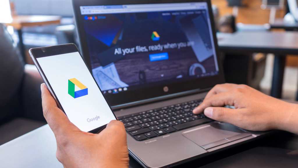 Google Drive on phone in hand and on laptop on desk