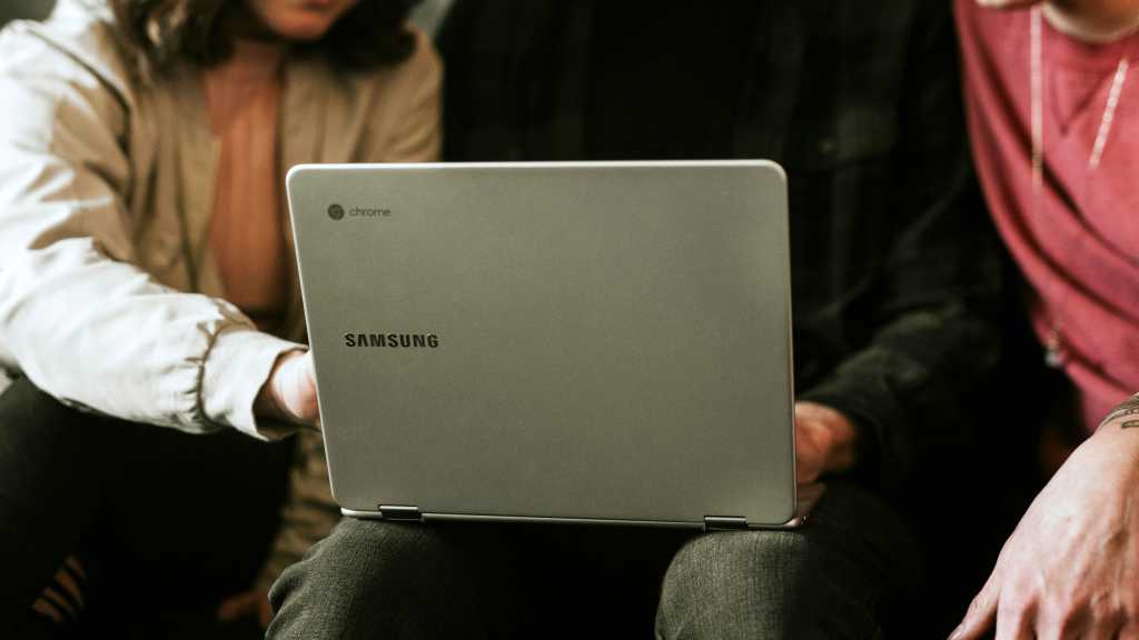 Samsung Chromebook in lap of user being shared with two friends