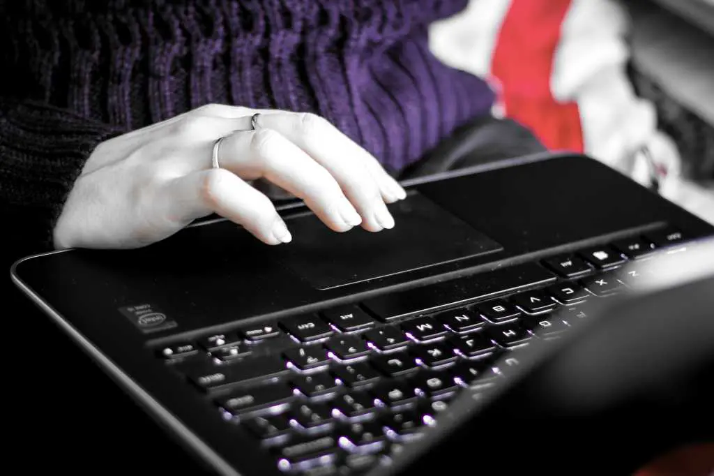 Student girl working on black laptop using the touchpad colorshifted