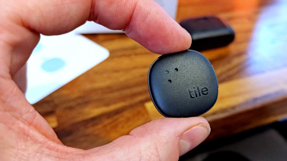 Tracker Bluetooth collant en carreau tenu entre les doigts