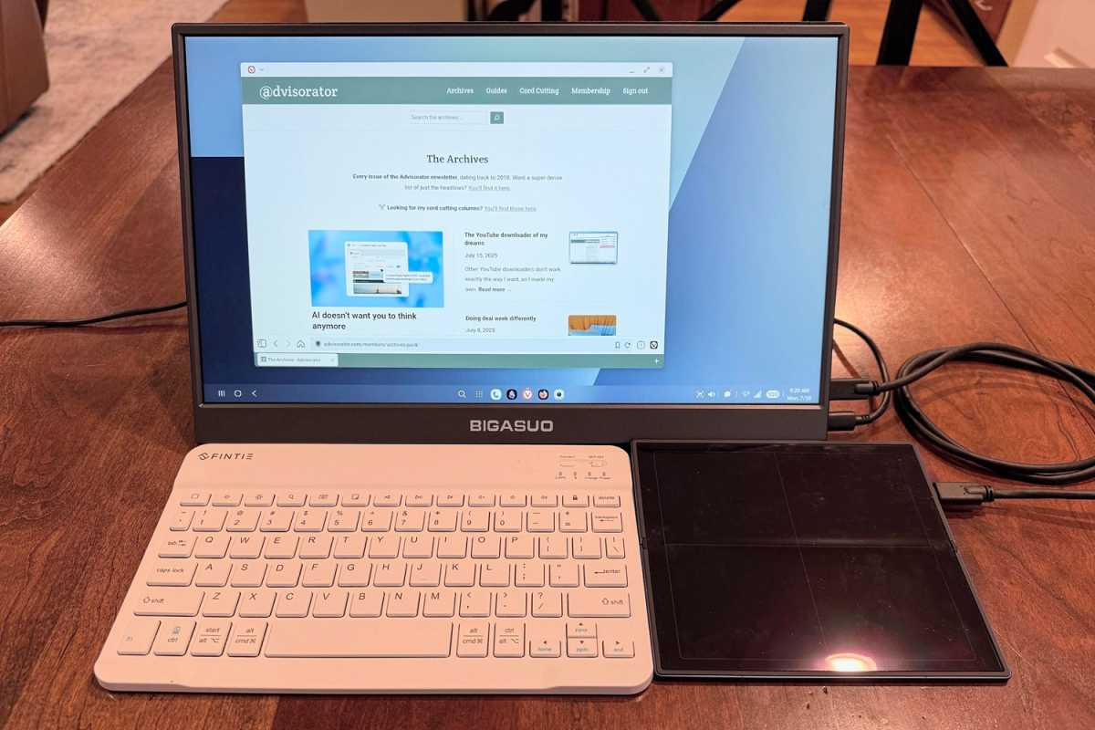 Un moniteur portable, un clavier Bluetooth et un téléphone pliable Samsung en mode DEX, doublant en tant que trackpad