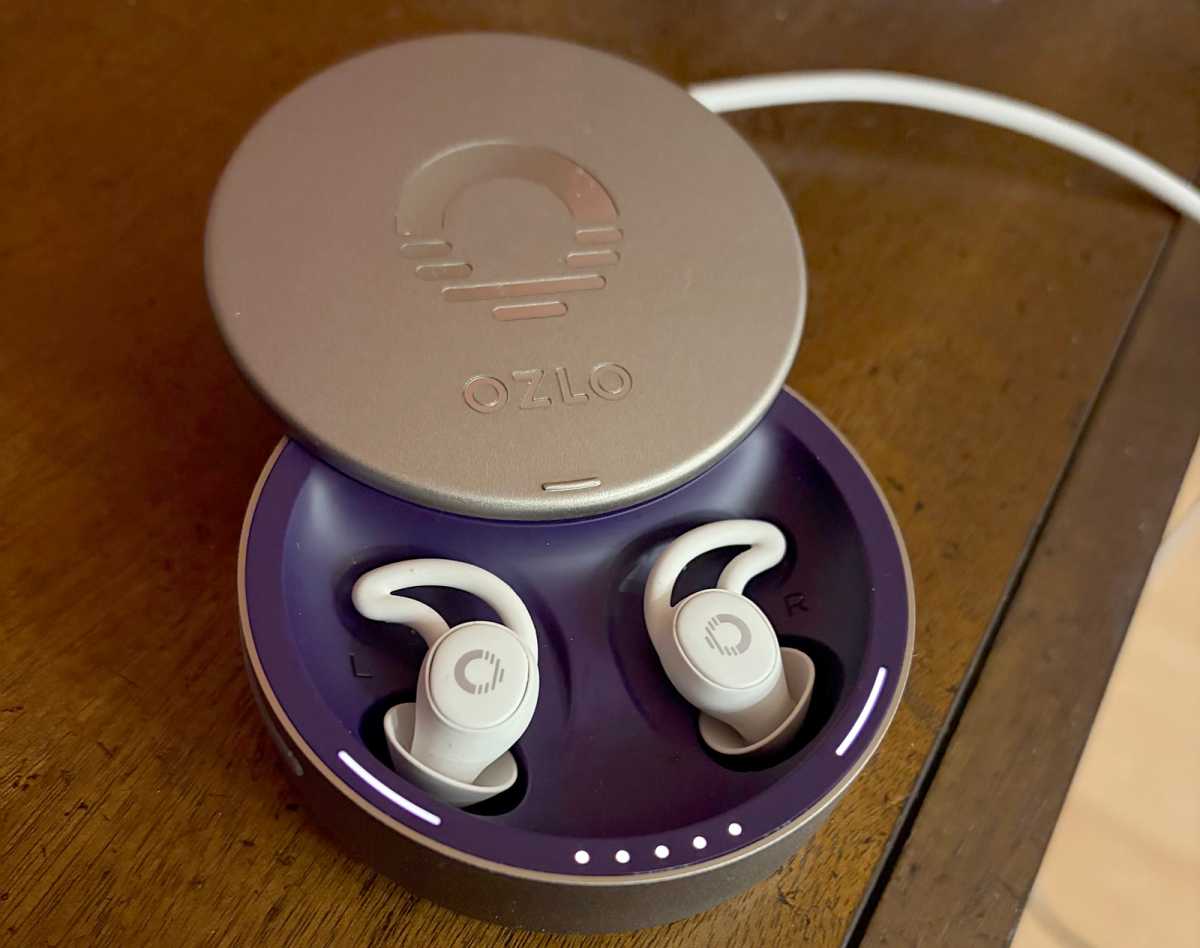 Les Ozlo Sleepbuds, dans leur écrin, sur un bureau en bois.
