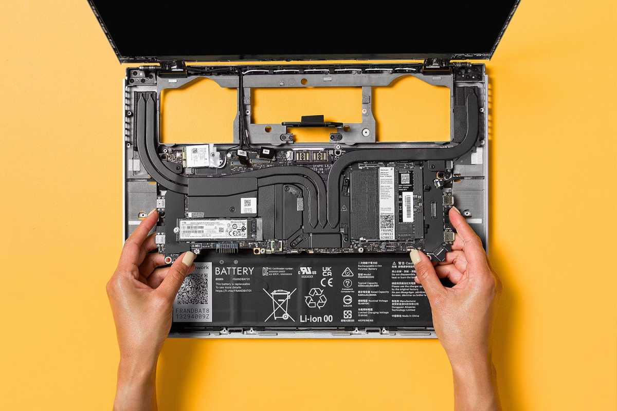 Ordinateur portable Framework avec composants internes ouverts sur fond jaune