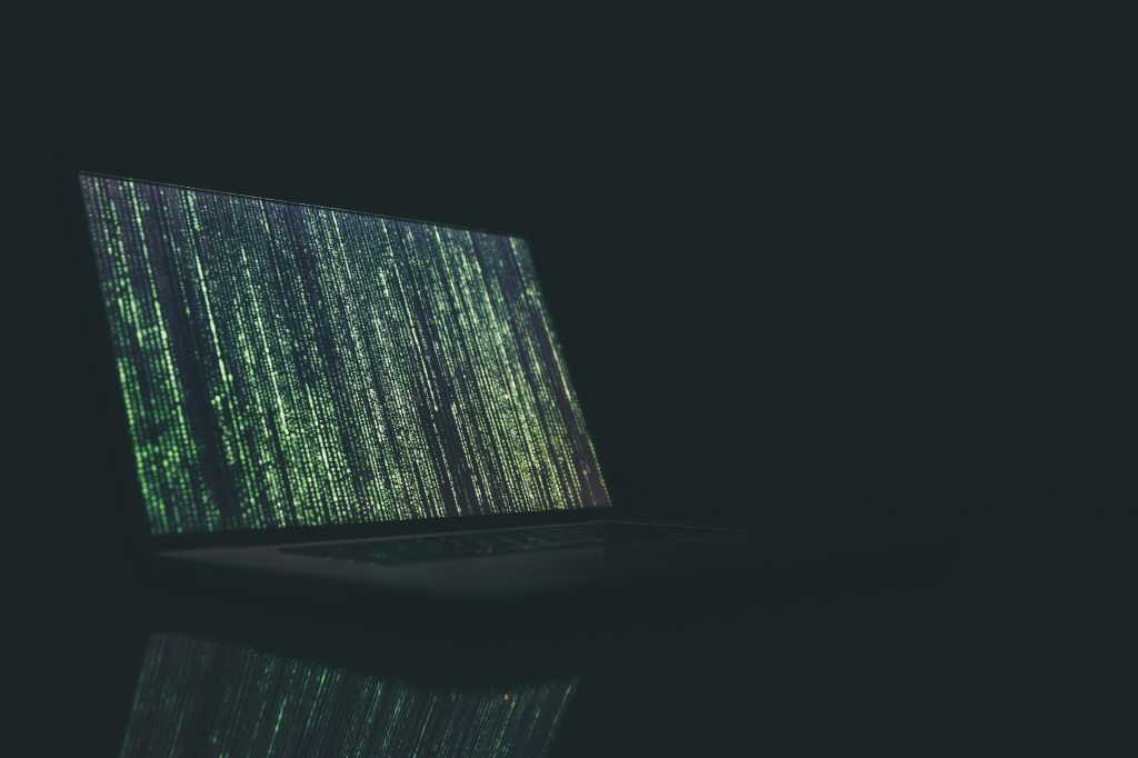 Fake code glitch on a laptop in a dark room