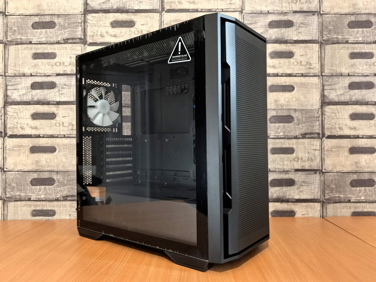 A modern black computer case with tempered glass panel on a wooden desk, ideal for tech enthusiasts.