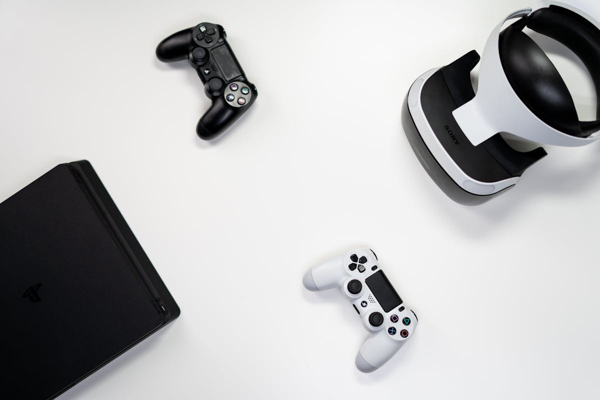 Flat lay of gaming console, controllers, and VR headset on a white background.