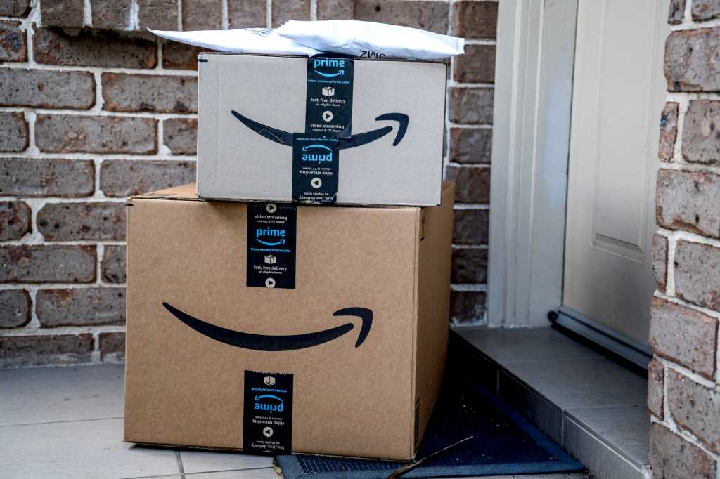 Amazon box packages delivered at front door of house