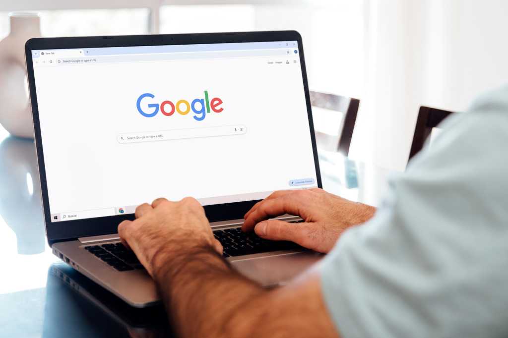 Man typing on laptop with Google Chrome on screen