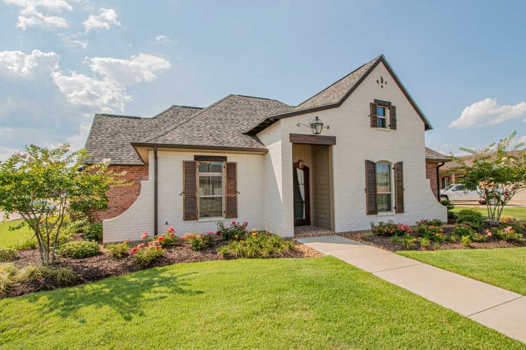 View of a detached single family home with a lawn on sunny day