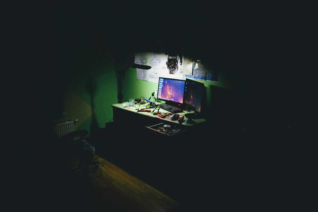 computer on a desk in a dark room