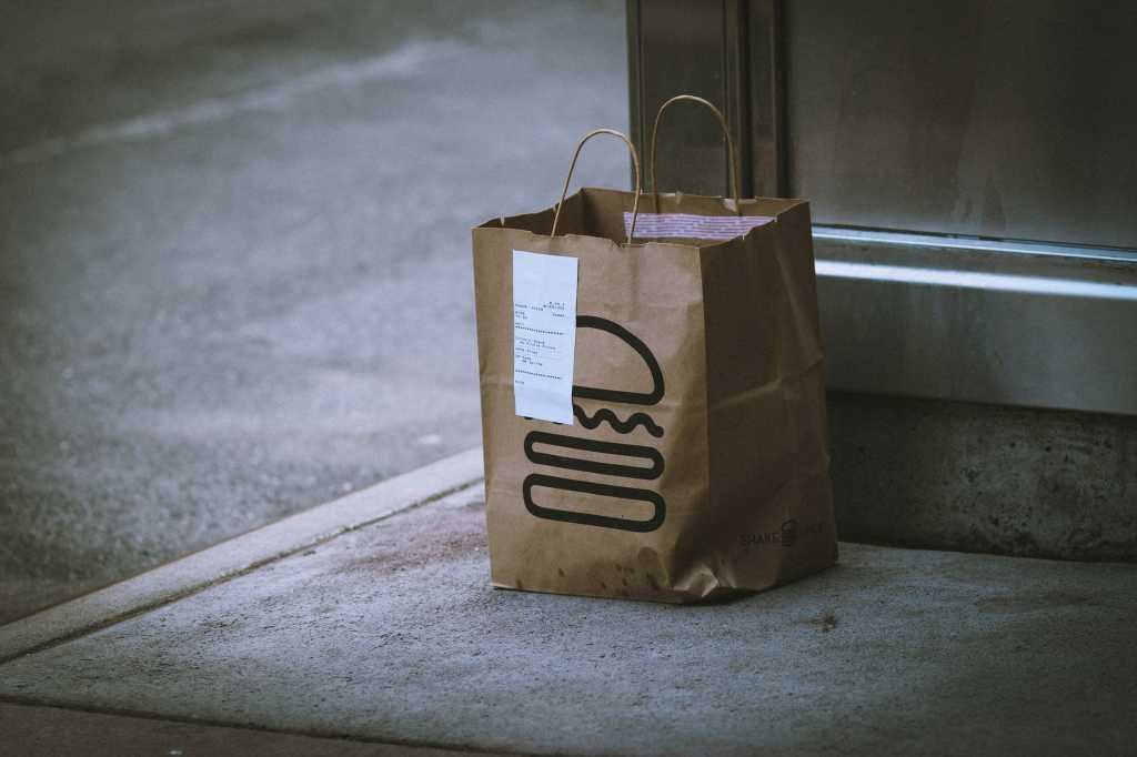 Shake Shack pickup order bag with receipt attached on a street