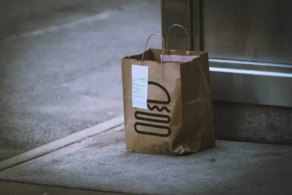 Shake Shack pickup order bag with receipt attached on a street