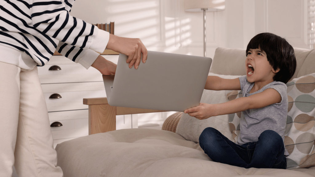 Mutter mit schreiendem Kind und Laptop