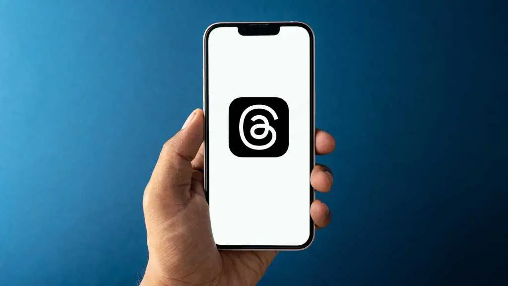 Meta Threads app icon on phone held in hand