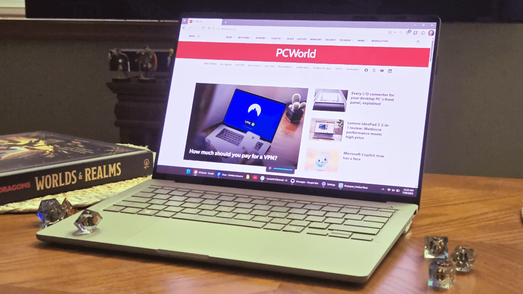 Asus Zenbook A14 laptop on table with dice and book