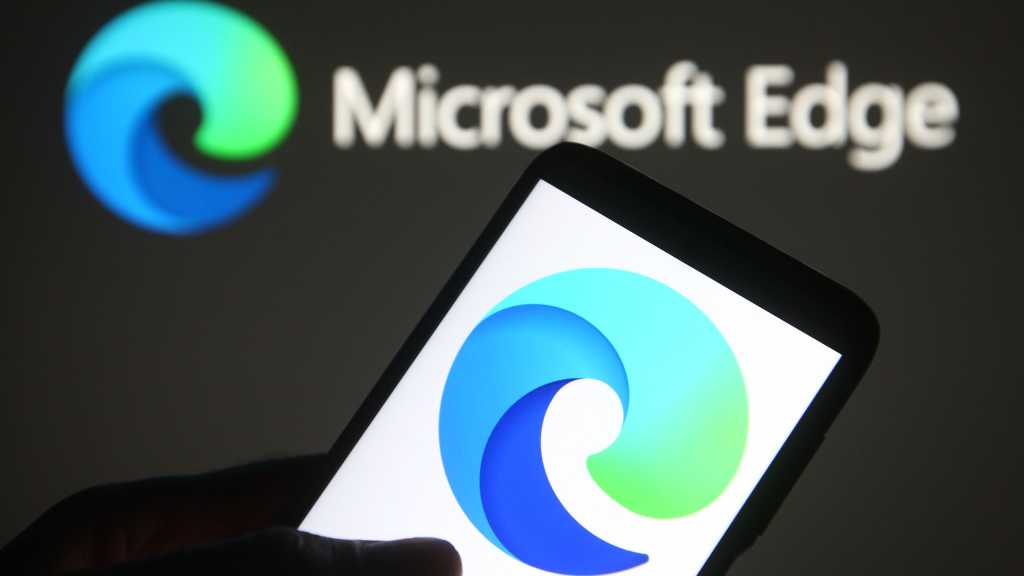 An illustration of Microsoft Edge logo is seen on a mobile phone in a hand.