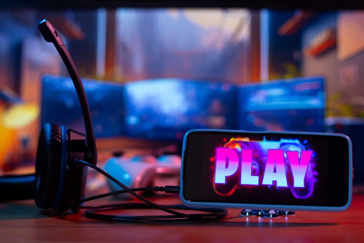 Installation d'un joueur sur smartphone avec un jeu vidéo sur l'écran et un bouton de lecture visible