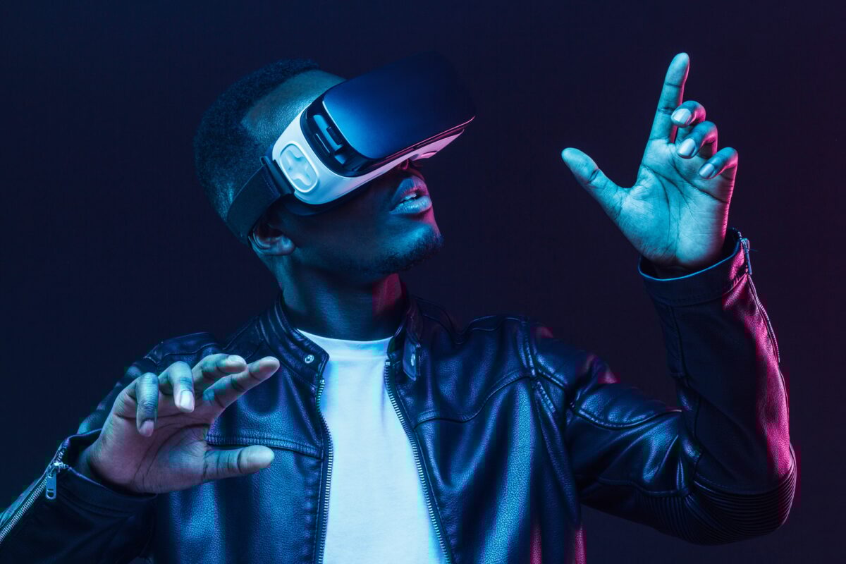 Neon portrait of young african man having virtual reality experience using vr headset